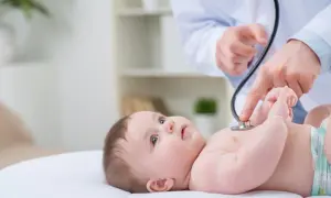 Lekarz osłuchuje dziecko, sprawdzając, czy nie ma szmerów w sercu.