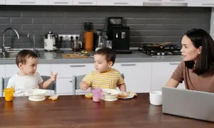 Mama słucha, kiedy chłopcy zaczynają mówić, jedząc śniadanie w kuchni.