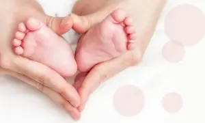 Dłonie tworzą serce wokół małych stópek, symbolizując miłość i troskę o wagę 3 miesięcznego dziecka.